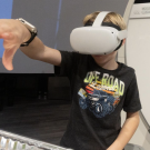Child with a virtual reality headset on tries to solve a puzzle