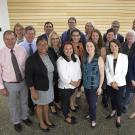 Group of UC Davis members wear professional attire as they smile for a group photo